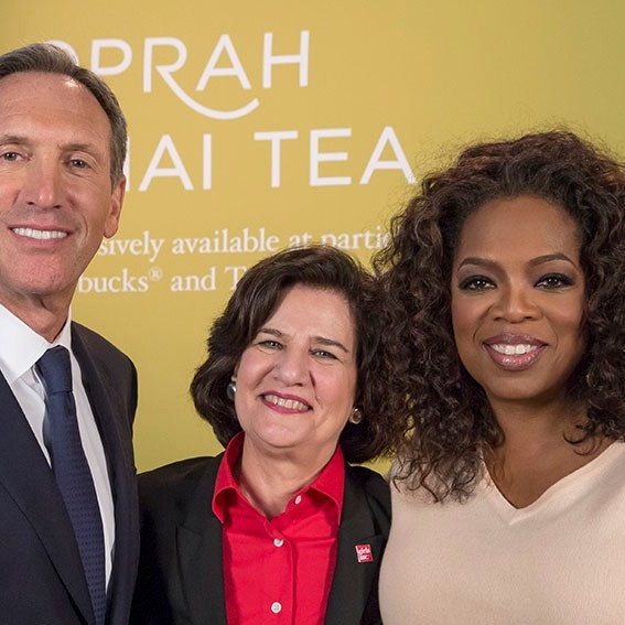 Alum in center of photo with former Starbucks CEO and media mogul Oprah Winfrey. 