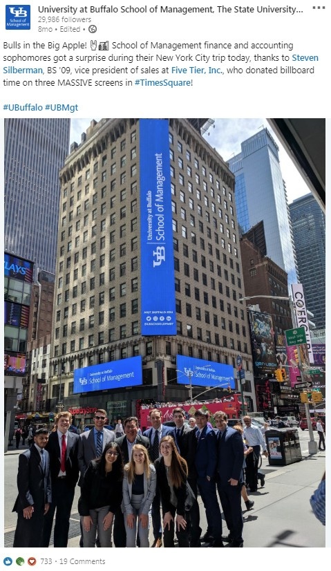 LinkedIn post with a photo of students in New York City and the following message: Bulls in the Big Apple! School of Management finance and accounting sophomores got a surprise during their New York City trip today, thanks to Steven Silberman, who donated billboard time on three massive screens in Times Square! 