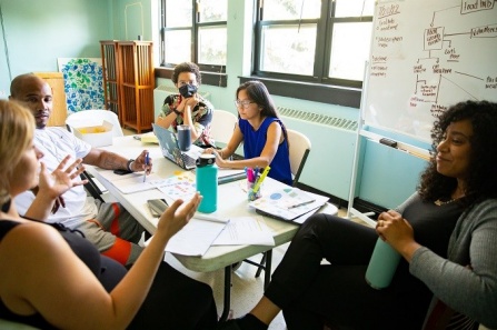 Interns collaborating with their supervisors in a team setting. Photographer: Meredith Forrest Kulwicki. 