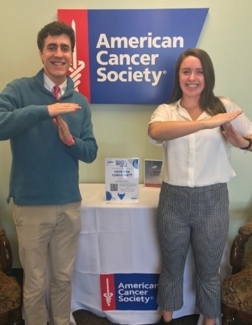 Student (Sean Sullivan) and Employer (Dylyn LaBarbera) standing in front of American Cancer Society table. 